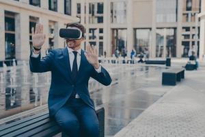 Young business owner in blue formal suit reviewing projects in virtual reality photo