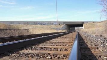 Train tracks with graffiti going under busy highway video