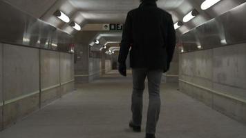 un homme traverse un tunnel souterrain dans le métro video