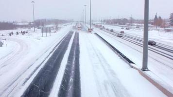 Ein Team riesiger Schneepflüge räumt die Autobahn in einem Schneesturm frei video