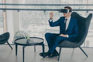 Overjoyed office worker wears VR headset, enjoying spending coffee break time in virtual reality photo