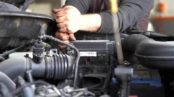 Car engine parts disassembly.  Masters who remove parts from car engine. Unscrewing with wrench. Greasy and dirty hands. video