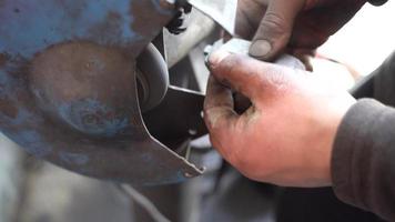 lijadora de piezas de coche. el maestro está lijando la parte del vehículo con la máquina. manos de trabajo en primer plano. video