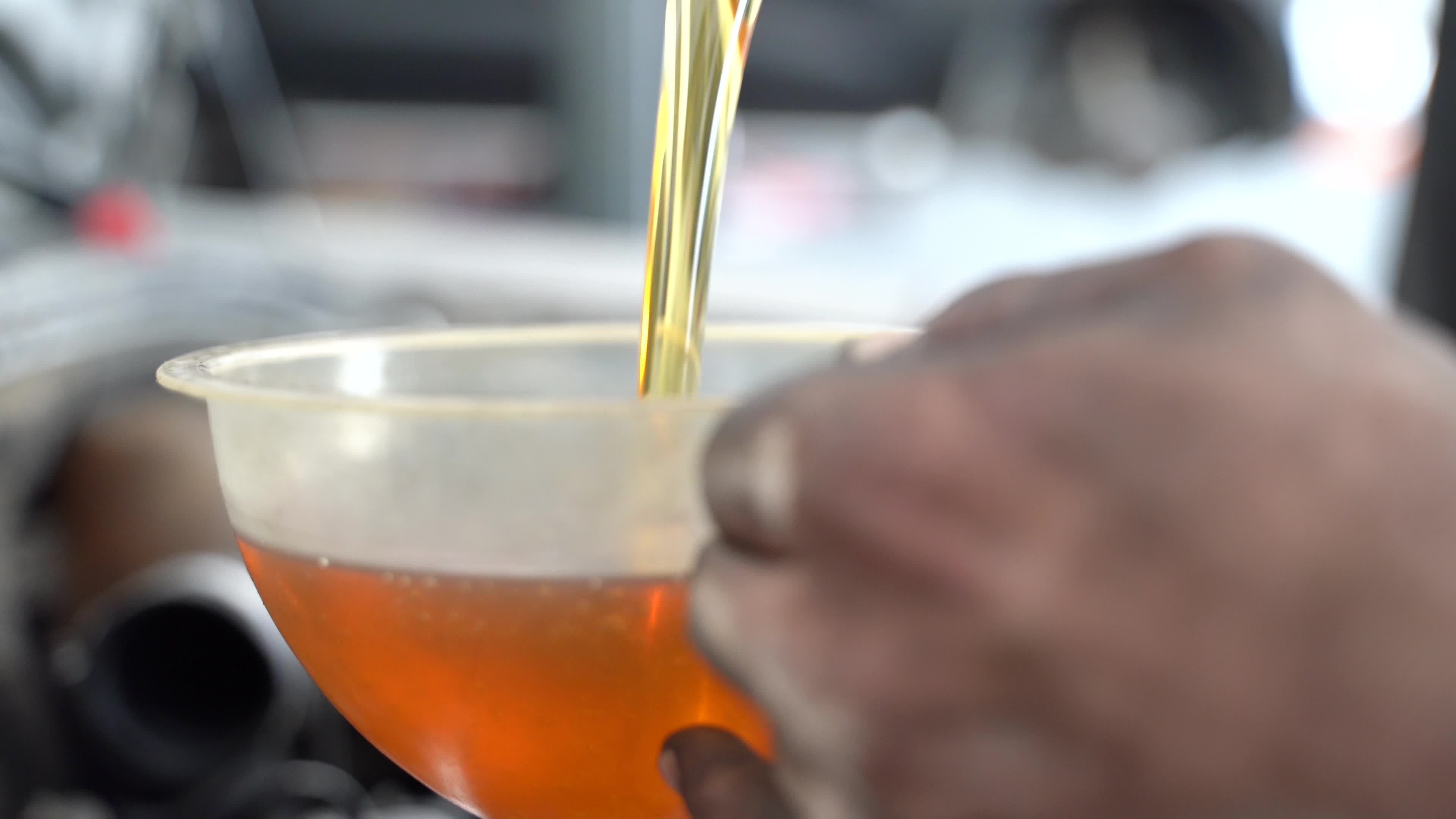 Car engine oil change. Adding new engine oil to the car, changing the ...