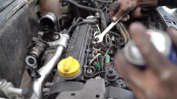 Master working on car engine. It's putting something on the engine and lubricating it. Dirty hands. video