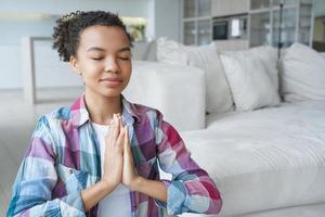 Spanish girl is sitting in lotus position with her eyes closed. Stress relief and mental health. photo