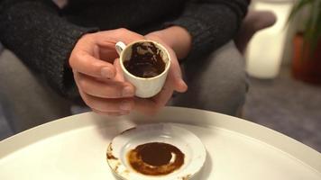 predizione del futuro, tazza di caffè. l'indovino alza la coppa e comincia a interpretare. interpreta e descrive ciò che vede. video