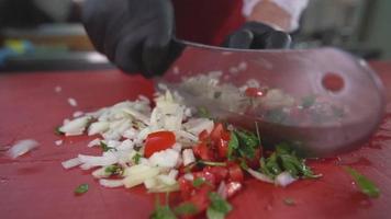 o cozinheiro preparando a salada. ele corta saladas com uma faca. video