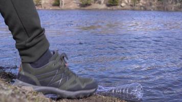 bouteille en plastique dans le lac. l'environnement et la pollution de l'eau. bouteille en plastique flottant dans le lac. un homme prend la bouteille en plastique du lac. il prévient la pollution de l'eau et de l'environnement. video