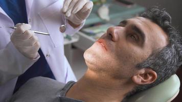 dentista, tratamento odontológico. o dentista trata os dentes de seu paciente com métodos modernos. video