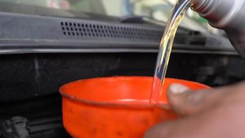 Car engine oil change. Adding new engine oil to the car, changing the engine oil with the help of a funnel. video