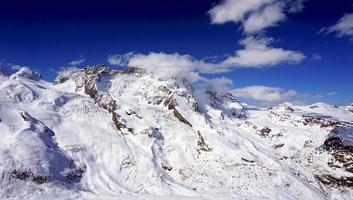 escena de las montañas de los alpes nevados y cielo azul foto