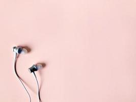 white ear phone on pastel pink color background summer photo