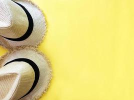 Two woven hats on pastel yellow color background summer horizontal photo