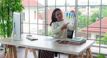 Work from home and online learning or meeting concept. Pretty young women working on computer using smartphone in the living room or co-working space. photo