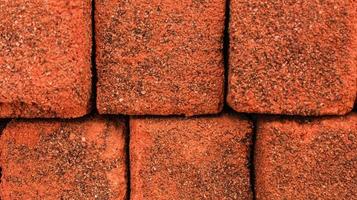 Arrangement of solid clay bricks used for construction, dark red brick, closeup view of red bricks as building materials, arrangement of brickwork photo