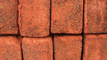 Arrangement of solid clay bricks used for construction, dark red brick, closeup view of red bricks as building materials, arrangement of brickwork photo