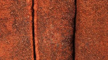 Rows of sandy red bricks. Red background of red bricks. arrangement of solid clay bricks used for construction, dark red brick, closeup view of red bricks as building materials, pile of brickwork photo