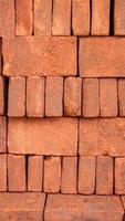 Portrait view of arrangement of solid clay bricks used for construction, dark red brick, closeup view of red bricks as building materials, pile of brickwork photo