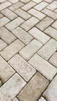 motivo de piso de ladrillos de cemento rectangulares para su concepto de diseño. patrón de fondo geométrico del suelo de cemento rugoso. motivo de bloque de pavimentación. foto