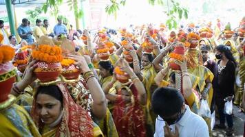 nueva delhi, india 03 de abril de 2022 - mujeres con kalash en la cabeza durante el templo jagannath mangal kalash yatra, devotos hindúes indios llevan ollas de barro que contienen agua sagrada con un coco encima video