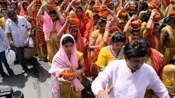 neu delhi, indien 03. april 2022 - frauen mit kalash auf dem kopf während des jagannath-tempels mangal kalash yatra, indische hindu-anhänger tragen irdene töpfe mit heiligem wasser mit einer kokosnuss darauf video