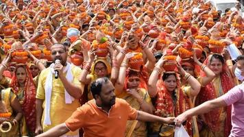 new delhi, inde 03 avril 2022 - femmes avec kalash sur la tête pendant le temple jagannath mangal kalash yatra, les dévots hindous indiens portent des pots en terre contenant de l'eau sacrée avec une noix de coco sur le dessus video