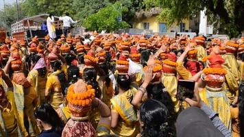 new delhi, inde 03 avril 2022 - femmes avec kalash sur la tête pendant le temple jagannath mangal kalash yatra, les dévots hindous indiens portent des pots en terre contenant de l'eau sacrée avec une noix de coco sur le dessus video