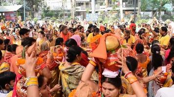 new delhi, india, 03 april 2022 - vrouwen met kalash op hoofd tijdens jagannath tempel mangal kalash yatra, indische hindoe toegewijden dragen aarden potten met heilig water met een kokosnoot erop video