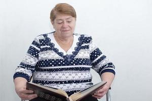 an elderly woman looks at a photo album