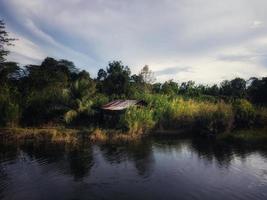 view of old house, tropical forest and lake photo