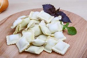 Raw ravioli on a board photo