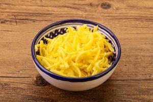 Shredded yellow cheese in the bowl photo