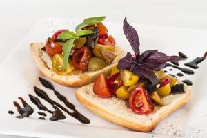 juicy tomatoes on fresh bread, pesto as topping photo