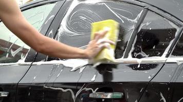 hands hold sponge for washing car