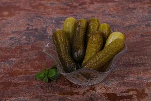 Pickled cucumbers heap in the bowl photo