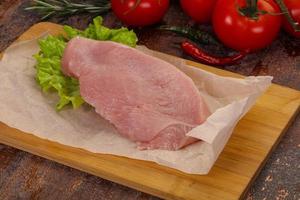Raw Turkey steak served rosemary photo