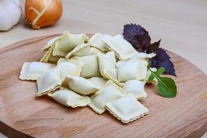 Raw ravioli on a board photo