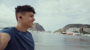 Latin young man, famous beach Rio de Janeiro, Brazil. Latin summer vacation holiday. Cinematic 4K.