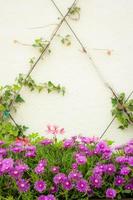 Part of a decorated wall with purple flowers. photo