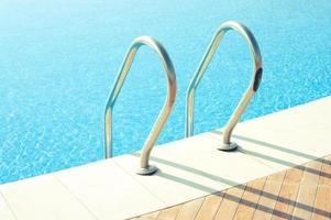 Beautiful swimming pool with shiny handrails under the bright sunlight.