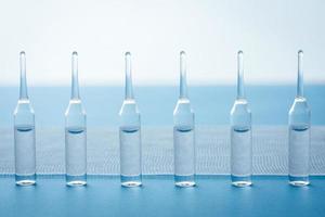 Ampules standing in a row on blue background. photo