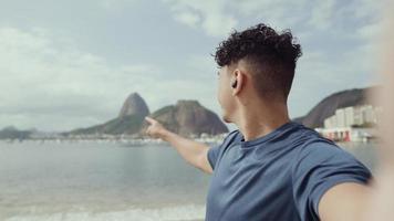 jeune homme latin, célèbre plage rio de janeiro, brésil. vacances d'été latines. cinématique 4k. video