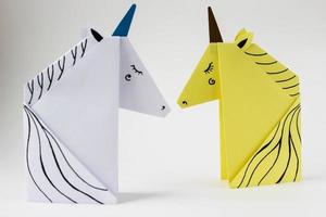 White and yellow unicorns made in the origami technique on white background. photo