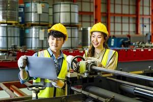 equipo de trabajadores ingenieros asiáticos que inspeccionan el interior de la fábrica de acero mientras escuchan los consejos del gerente sobre la mejora del concepto de capacidad y productividad foto