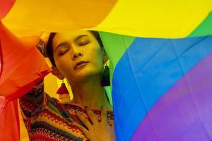 Elegance transgender model woman in colorful rainbow flag costume is dancing in homosexual parade for LGBTQ pride month and coming out of the closet concept for sexual equality and freedom concept
