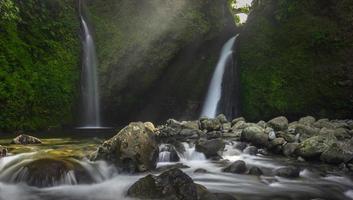 beautiful morning view with sunshine on waterfall in Indonesian tropical forest photo