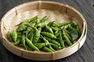 Green Small Indonesian Chilli or Cabe Ijo for Gorengan, Served on Bamboo Plate photo