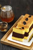 Spiku or Lapis Surabaya, Indonesian  Three Layer Cake with with Strawberry Jam Between the Layer. Topped with Prunes. Served with Tea, Perfect for Tea Time photo