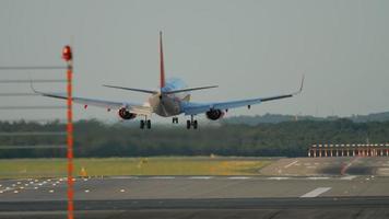 Airplane landing at 05R runway Dusseldorf airport, evening sunset rays video